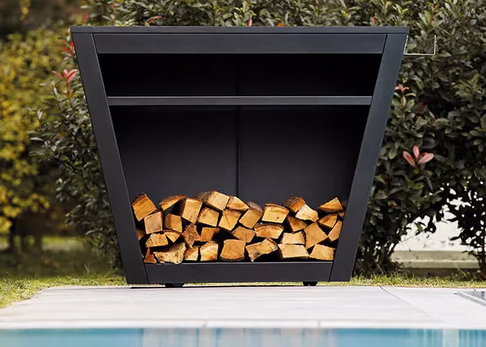 Außengrilltheke mit geometrischem schwarzem Metallrahmen und mit Brennholz gefülltem unterem Fach, neben einem Pool.