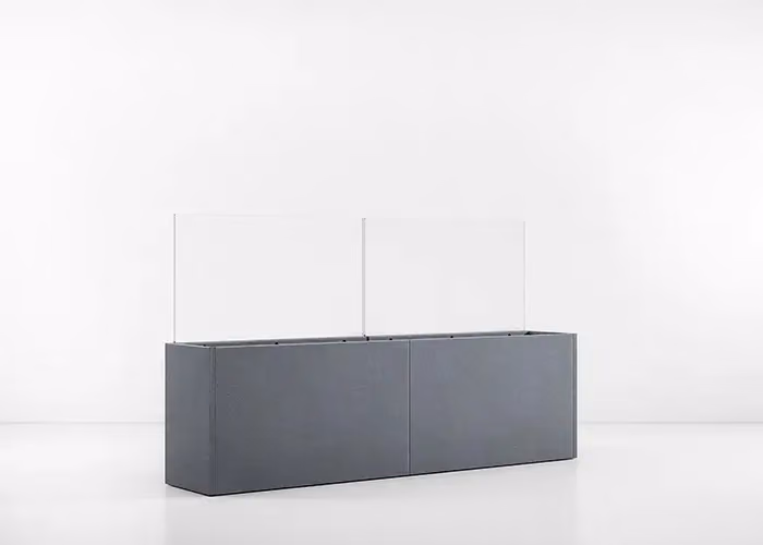 Fioriera rettangolare moderna in metallo grigio scuro con pannelli divisori trasparenti in vetro, fotografata su sfondo bianco minimalista.