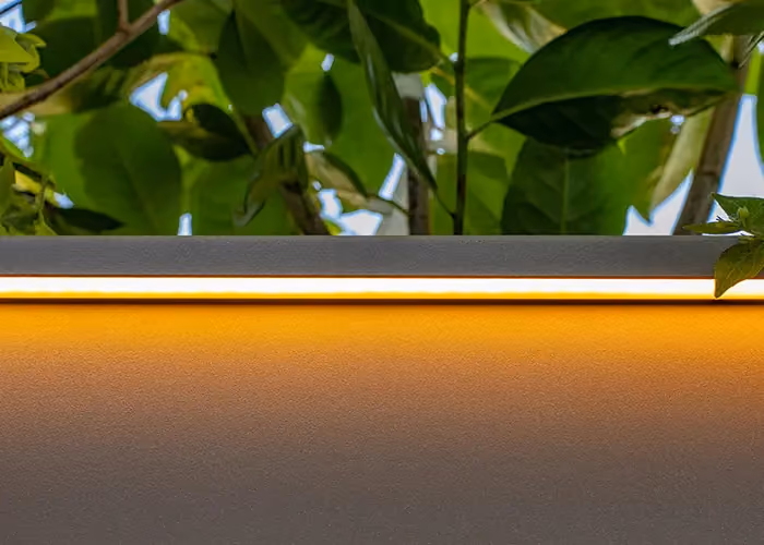 Integriertes LED-Beleuchtungssystem von Modularte für Außenpflanzgefäße: Detail der warmen Lichtverteilung und der technischen Randgestaltung.