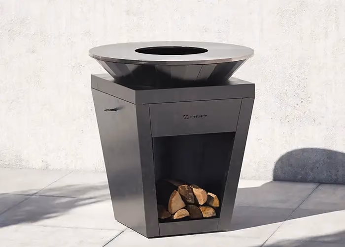 Moderner anthrazitfarbener Außengrill mit runder Kochplatte und Holzfach darunter.