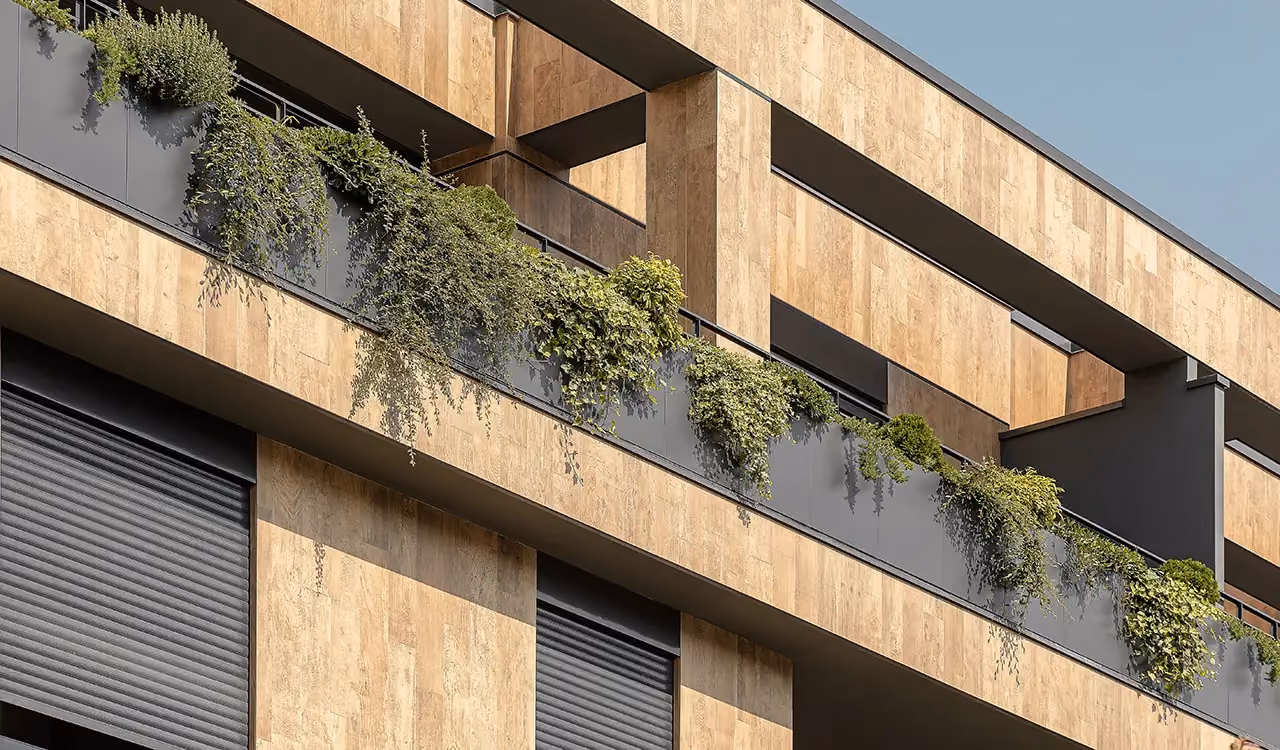Facciata in pietra chiara con fioriere lineari integrate nei parapetti dei balconi