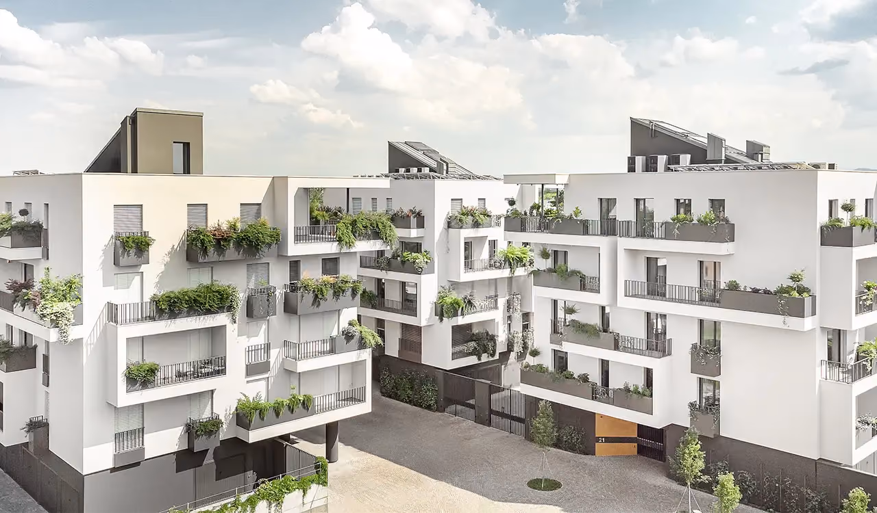 Vue extérieure d'un ensemble d'immeubles résidentiels blancs et modernes, aux nombreux balcons décalés ornés de grands bacs gris remplis de plantes vertes.
